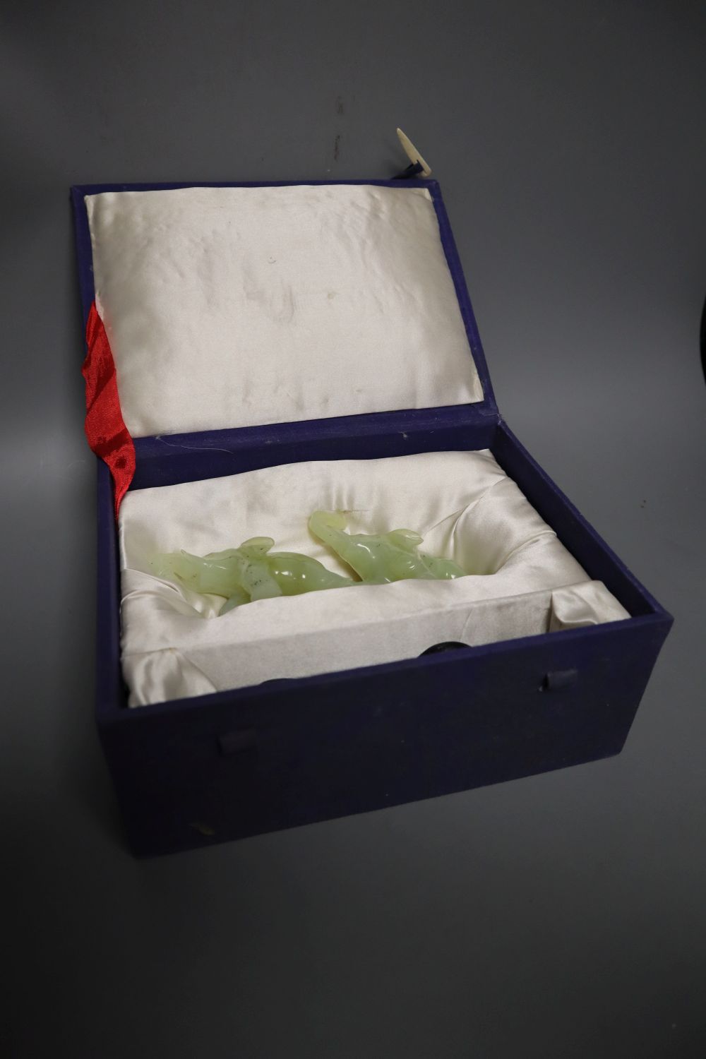 A carved bowenite jade group of two elephants, 16cm long with stand, boxed